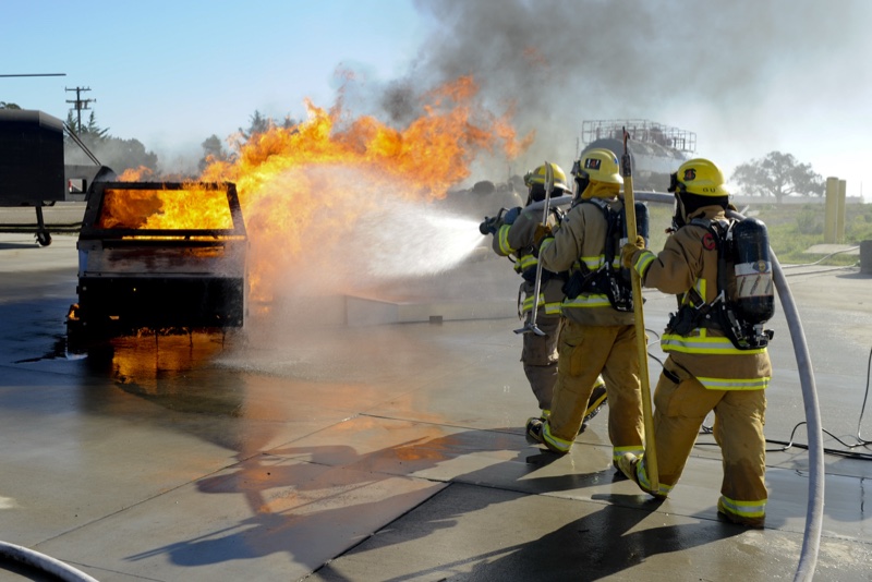 Bombeiros apagando um incêndio num container de lixo