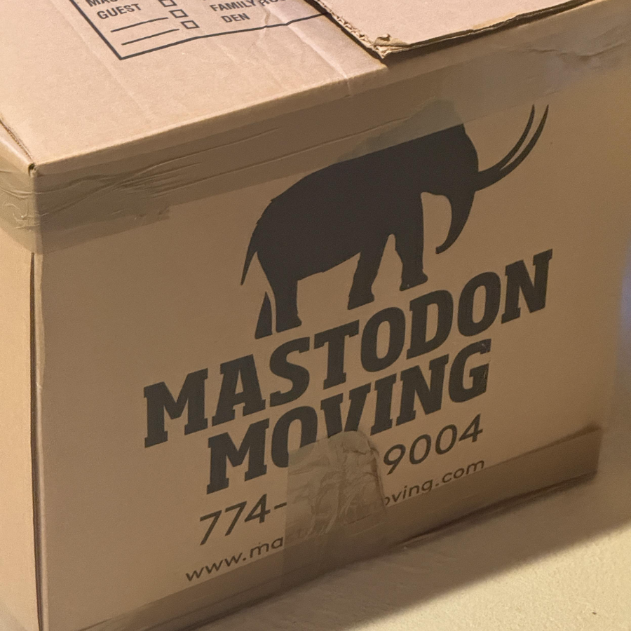 Uma caixa de papelão em que há um desenho de um mastodonte e as palavras: Mastodon Moving