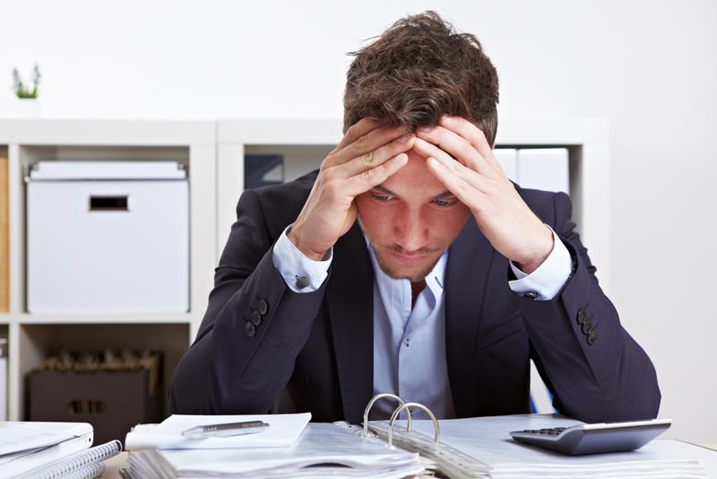 Uma pessoa em expressão de frustração, no ambiente de trabalho